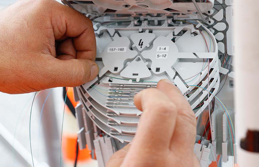 Technicien intervenant sur un répartiteur fibre – modèle à quatre fibres par unité sur le réseau Pully4net